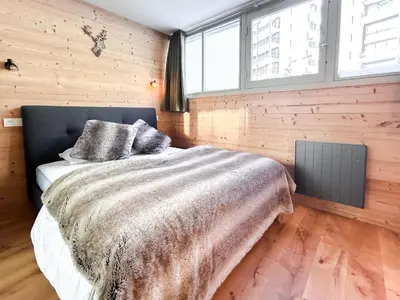 a bedroom with a bed with a blanket and two pillows at Next to the pistes, 1-bedroom family apartment in Flaine