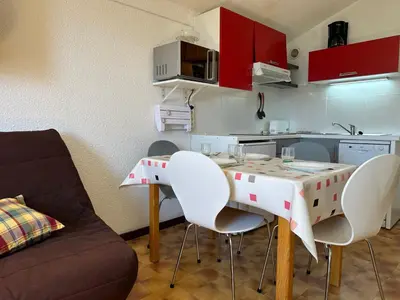 a kitchen with a table and chairs in a room at Appartement skis aux pieds à Samoëns 1600 - FR-1-624-79 in Samoëns