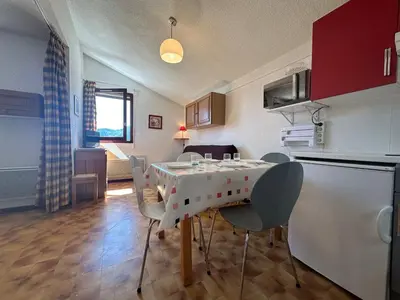 a kitchen with a table and chairs in a room at Appartement skis aux pieds à Samoëns 1600 - FR-1-624-79 in Samoëns