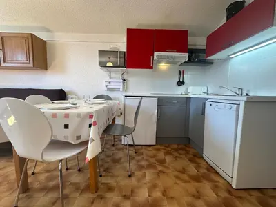 a kitchen with a table and chairs in a kitchen at Appartement skis aux pieds à Samoëns 1600 - FR-1-624-79 in Samoëns