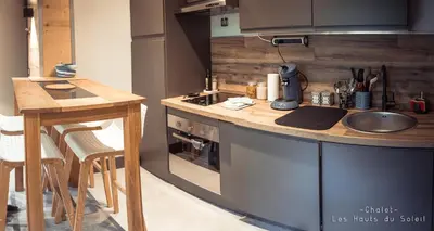 a kitchen with a counter and a sink and a stove at Appartement Chalet Les hauts du soleil in Chamonix-Mont-Blanc