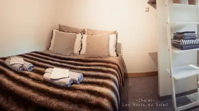 a bedroom with a bed with towels on it at Appartement Chalet Les hauts du soleil in Chamonix-Mont-Blanc