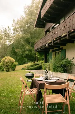 a table and chairs sitting in the grass at Appartement Chalet Les hauts du soleil in Chamonix-Mont-Blanc