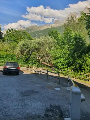 a car parked in a parking lot with mountains in the background at Appartement Chalet Les hauts du soleil in Chamonix-Mont-Blanc