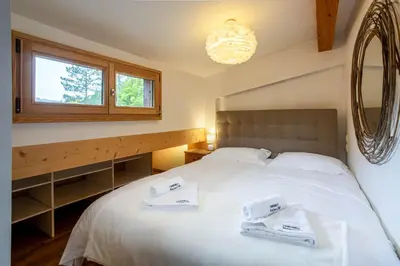 a bedroom with a bed with two towels on it at Neige Apartment - Chamonix All Year in Chamonix-Mont-Blanc
