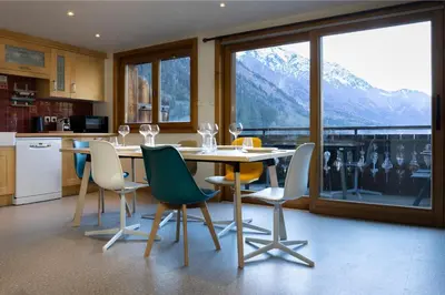 a kitchen with a table and chairs with a mountain view at La Snaille des Planards in Chamonix-Mont-Blanc
