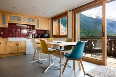 a kitchen with a table and chairs with a mountain view at La Snaille des Planards in Chamonix-Mont-Blanc