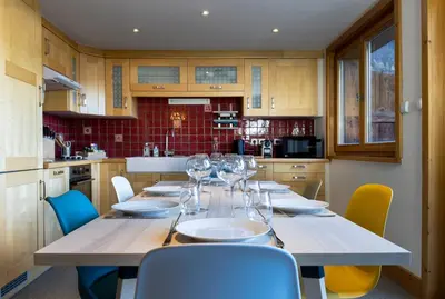 a kitchen with a table with wine glasses on it at La Snaille des Planards in Chamonix-Mont-Blanc