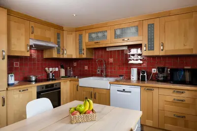 a kitchen with wooden cabinets and a bowl of fruit on a table at La Snaille des Planards in Chamonix-Mont-Blanc