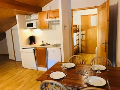 a kitchen and dining room with a wooden table and chairs at Studio avec balcon et animaux admis - FR-1-629-92 in Samoëns