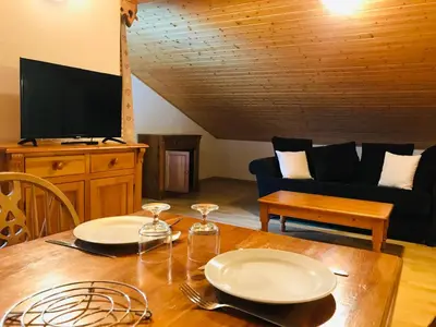 a living room with a wooden table with plates on it at Studio avec balcon et animaux admis - FR-1-629-92 in Samoëns
