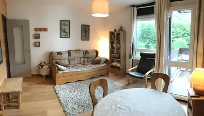 a living room with a couch and a table at Appartement proche village et remontées mécaniques in Saint-Gervais-les-Bains