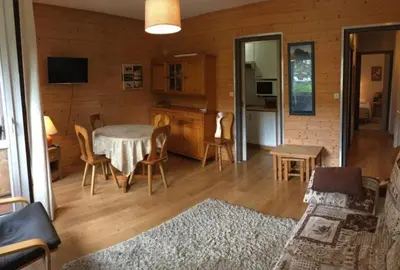 a living room with a table and chairs and a kitchen at Appartement proche village et remontées mécaniques in Saint-Gervais-les-Bains