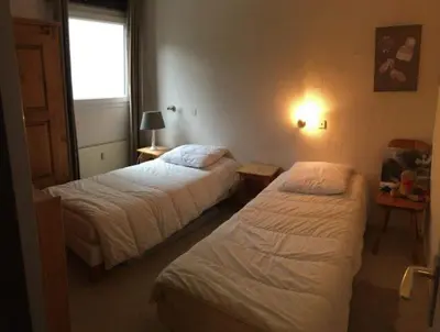 a hotel room with two beds and a window at Appartement proche village et remontées mécaniques in Saint-Gervais-les-Bains