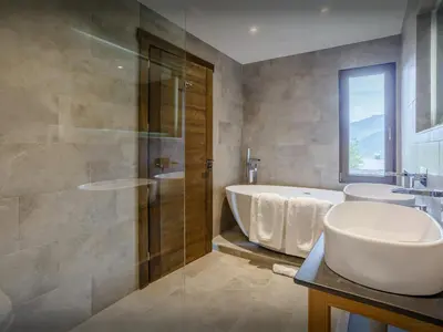 a bathroom with two sinks and a tub and a shower at Chalet Woodman - OVO Network in Saint-Gervais-les-Bains