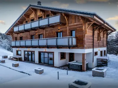 a log cabin in the snow with a balcony at Chalet Woodman - OVO Network in Saint-Gervais-les-Bains