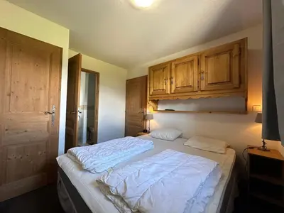 a bedroom with a bed and a table with a lamp at Confortable appartement 3 chambres avec WiFi pour 8 personnes - FR-1-642-7 in Morillon
