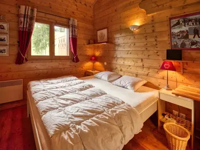 a bedroom with a large bed in a log cabin at Duplex 10 pers. au pied des pistes à Morillon - FR-1-642-2 in Morillon