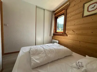 a bedroom with a bed in a room with a window at Appartement en montagne, 6 pers., balcon sud - FR-1-642-18 in Morillon