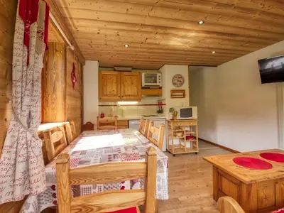 a dining room with a table and a kitchen at Appartement en montagne, 6 pers., balcon sud - FR-1-642-18 in Morillon