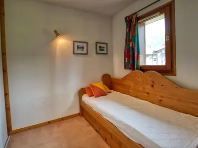 a bedroom with a bed and a large window at Duplex pieds des pistes avec parking et animaux acceptés - FR-1-642-19 in Morillon