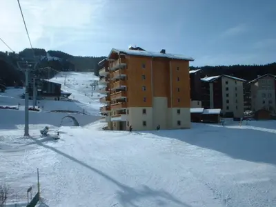 a tall building on the side of a road at Duplex pieds des pistes avec parking et animaux acceptés - FR-1-642-19 in Morillon