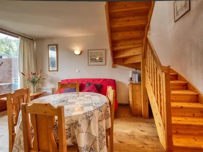 a room with a bed and a red couch and stairs at Duplex pieds des pistes avec parking et animaux acceptés - FR-1-642-19 in Morillon