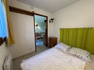 a bedroom with a bed and a green curtain at Appartement confortable pour 6 pers. avec balcon à Morillon - FR-1-642-11 in Morillon