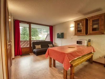 a living room with a table and a couch at Appartement confortable 6 pers, proche jardin d'enfants - FR-1-642-15 in Morillon