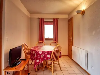 a dining room with a table and chairs and a television at Appartement confortable 6 pers au pied des pistes à Morillon - FR-1-642-37 in Morillon