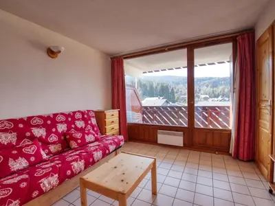 a living room with a red couch and a large window at Appartement confortable 6 pers au pied des pistes à Morillon - FR-1-642-37 in Morillon