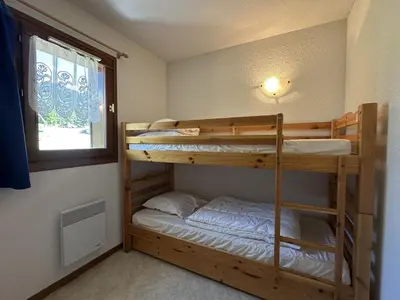 two bunk beds in a room with a window at Appartement confortable 6 pers proche jardin enfants - FR-1-642-24 in Morillon
