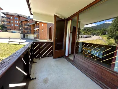 a balcony with two chairs and a view of trees at Appartement confortable 6 pers proche jardin enfants - FR-1-642-24 in Morillon