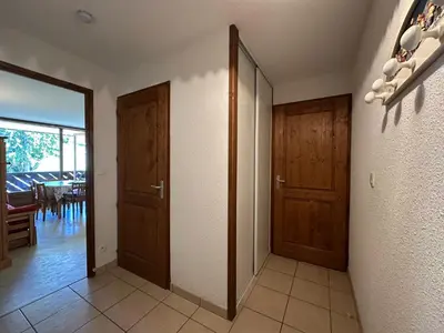 an empty hallway with two wooden doors and a room at Appartement confortable 6 pers proche jardin enfants - FR-1-642-24 in Morillon