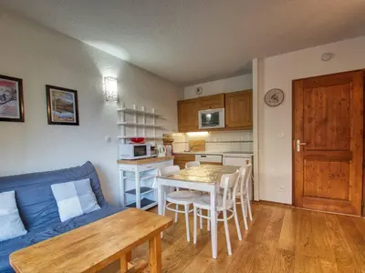 a living room with a table and a blue couch at Appartement 4 personnes, prox. pistes et jardin d'enfants - FR-1-642-41 in Morillon