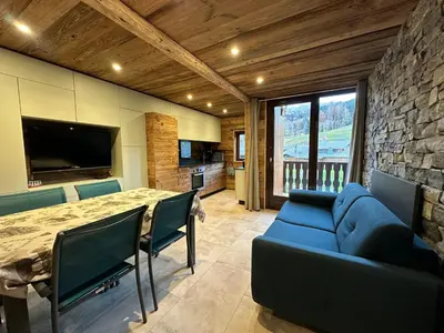 a living room with a blue couch and a table at Appartement duplex rénové 6p, expo sud - FR-1-642-56 in Morillon