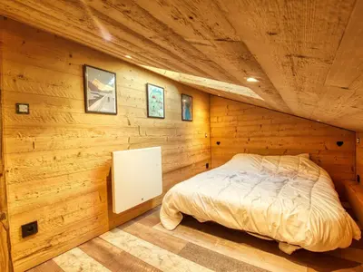 a bedroom in a log cabin with a bed at Appartement duplex rénové 6p, expo sud - FR-1-642-56 in Morillon