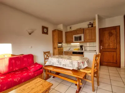 a living room with a red couch and a table at Appartement cosy 6 pers avec balcon en montagne - FR-1-642-53 in Morillon
