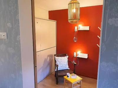 a room with a chair and a cabinet and a table at Chamonix Appartement Vue Mont Blanc avec jardin in Chamonix-Mont-Blanc