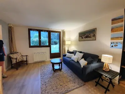 a living room with a couch and a table at Chamonix Appartement Vue Mont Blanc avec jardin in Chamonix-Mont-Blanc