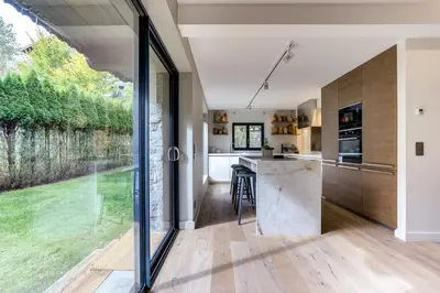 an open kitchen with a large window and a kitchen island at Chalet Alouette in Chamonix-Mont-Blanc