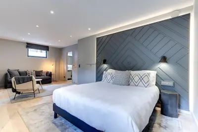 a bedroom with a large bed and a living room at Chalet Alouette in Chamonix-Mont-Blanc