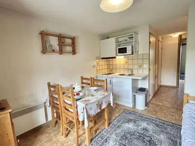 a small kitchen with a table and chairs in a room at Studio avec alcôve et cabine, 4 couchages à Demi-Quartier, parking inclus - FR-1-597-115 in Demi-Quartier