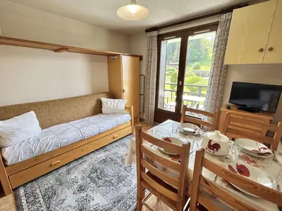 a bedroom with a bed and a dining table and a television at Studio avec alcôve et cabine, 4 couchages à Demi-Quartier, parking inclus - FR-1-597-115 in Demi-Quartier