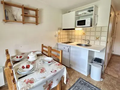 a small kitchen with a table and a sink at Studio avec alcôve et cabine, 4 couchages à Demi-Quartier, parking inclus - FR-1-597-115 in Demi-Quartier
