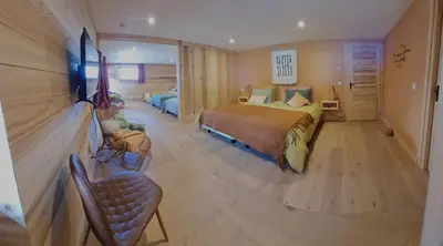 a bedroom with a bed and a chair in it at La Ferme des Fingères in Cordon