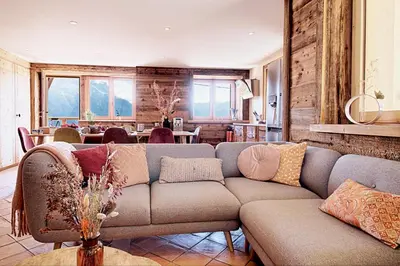 a living room with a couch and a table at La Ferme des Fingères in Cordon