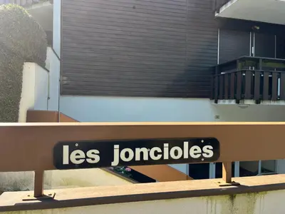 a sign on a bench in front of a building at Studio chaleureux avec balcon au centre de Samoëns - FR-1-624-83 in Samoëns
