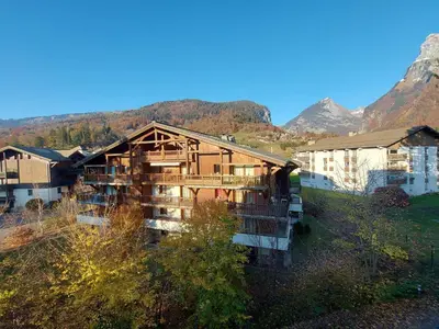 a log cabin with mountains in the background at Studio chaleureux avec balcon au centre de Samoëns - FR-1-624-83 in Samoëns