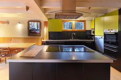 a kitchen with a large island in the middle at Chalet of the 5 Chardons ski-in ski-out in Les Houches